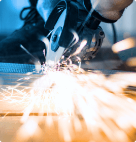 A dynamic shot of a saw cutting through an object on a table as sparks spray toward the viewer.
